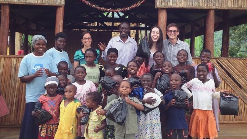 Sydney Kamen standing with a group of children in Uganda