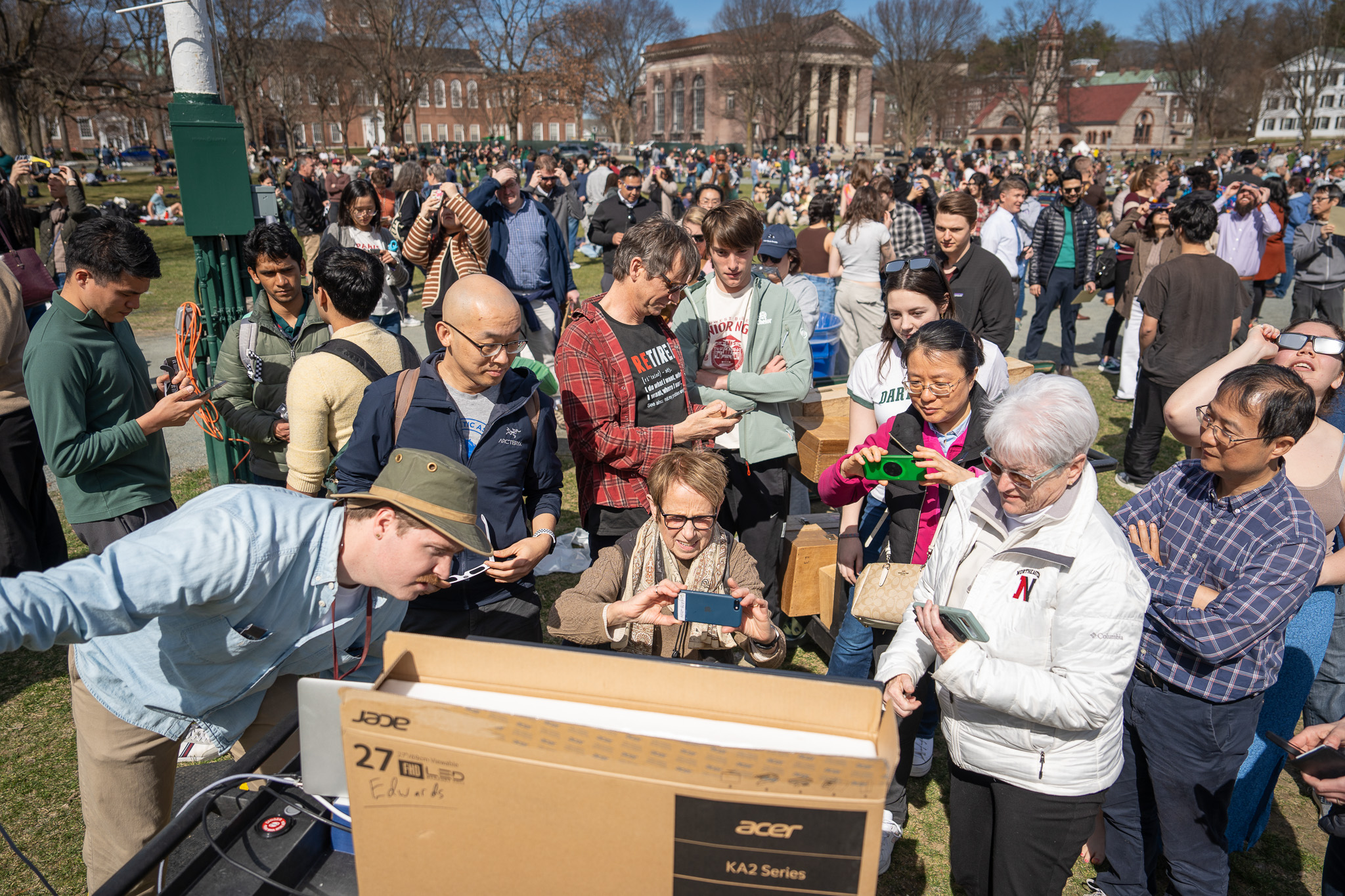 People look through a monitor out on the Dartmouth Green