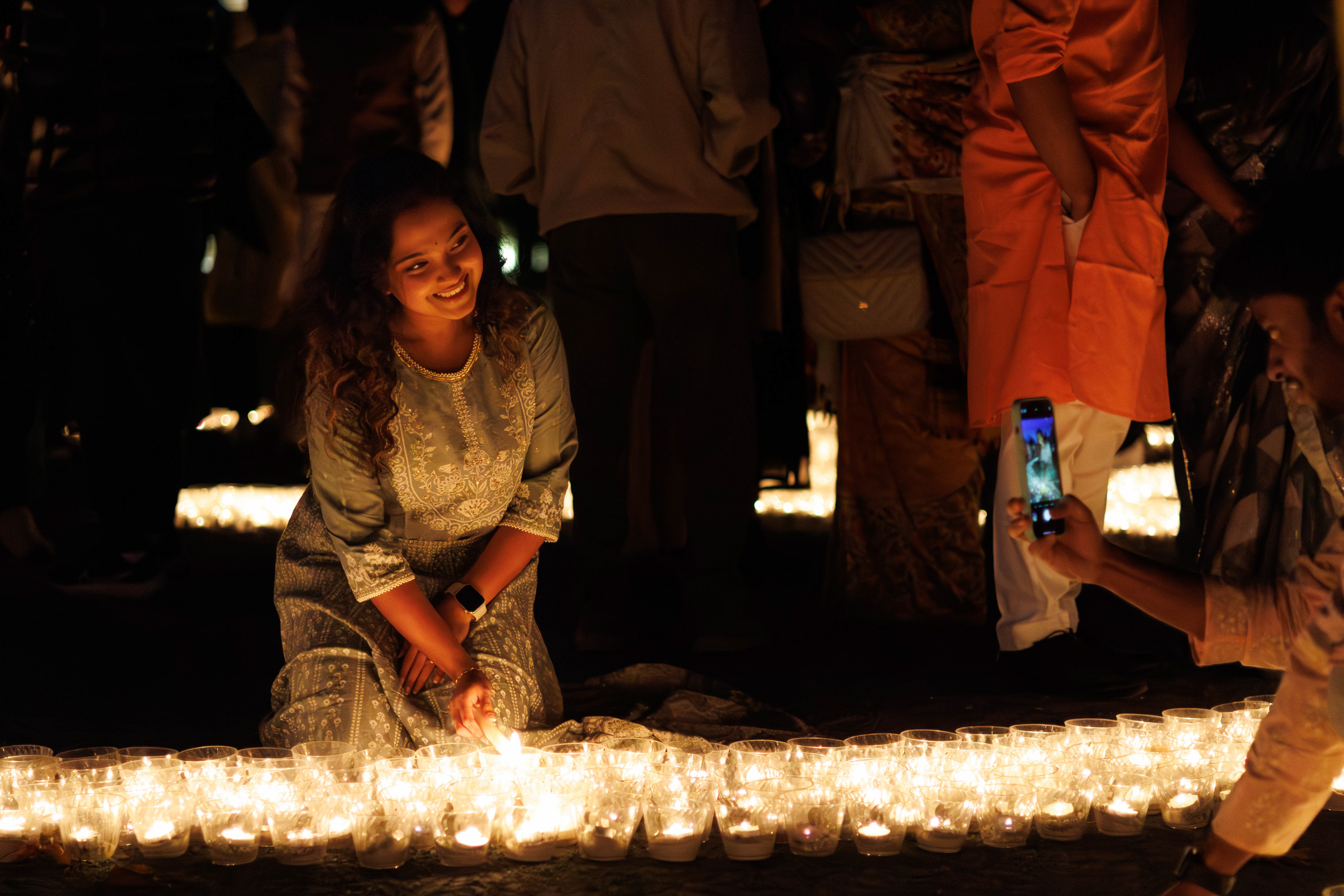 Person lights candle for Diwali