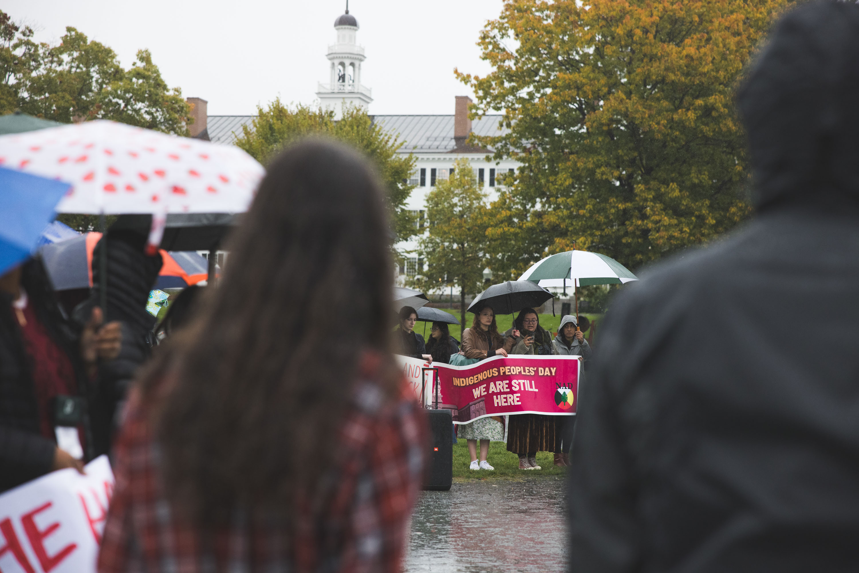 Students on the Green with signs and umbrellas