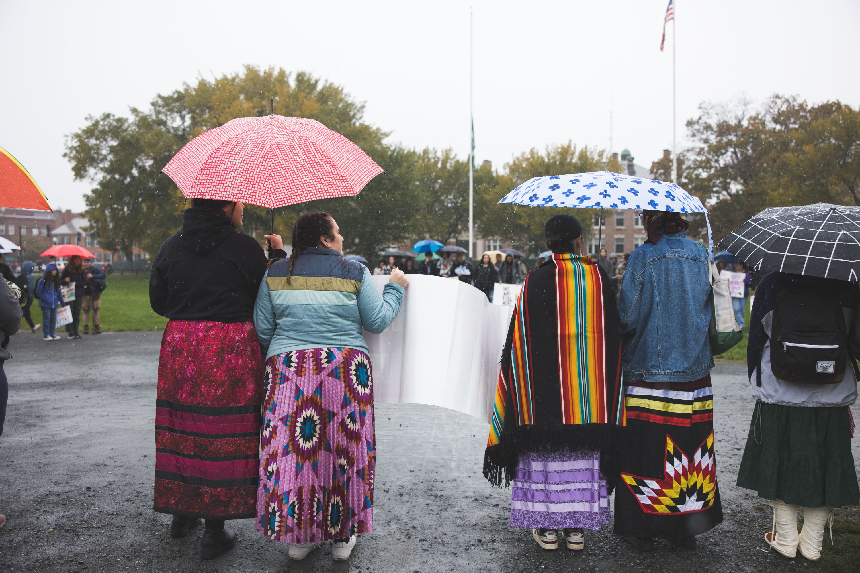 Students on the Green with signs and umbrellas