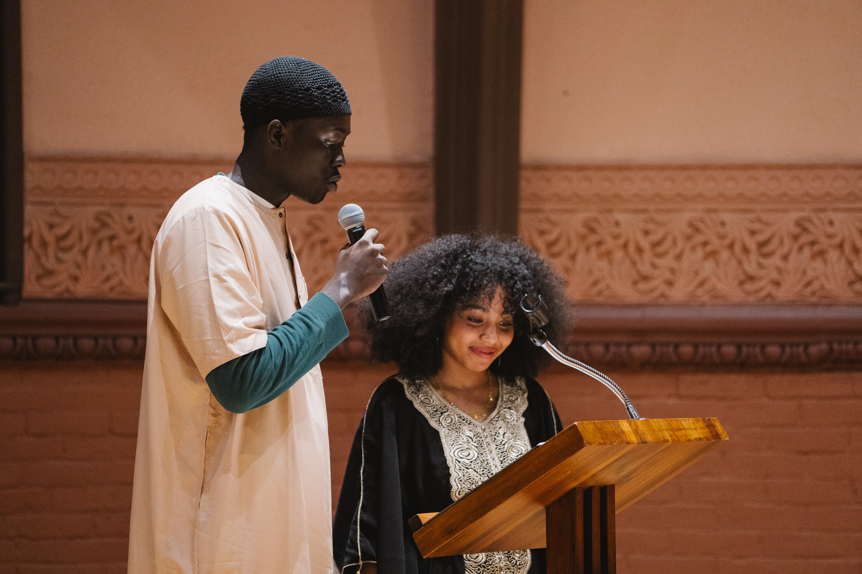 Baila Diallo and Abdullah Kalonji speaking at a podium
