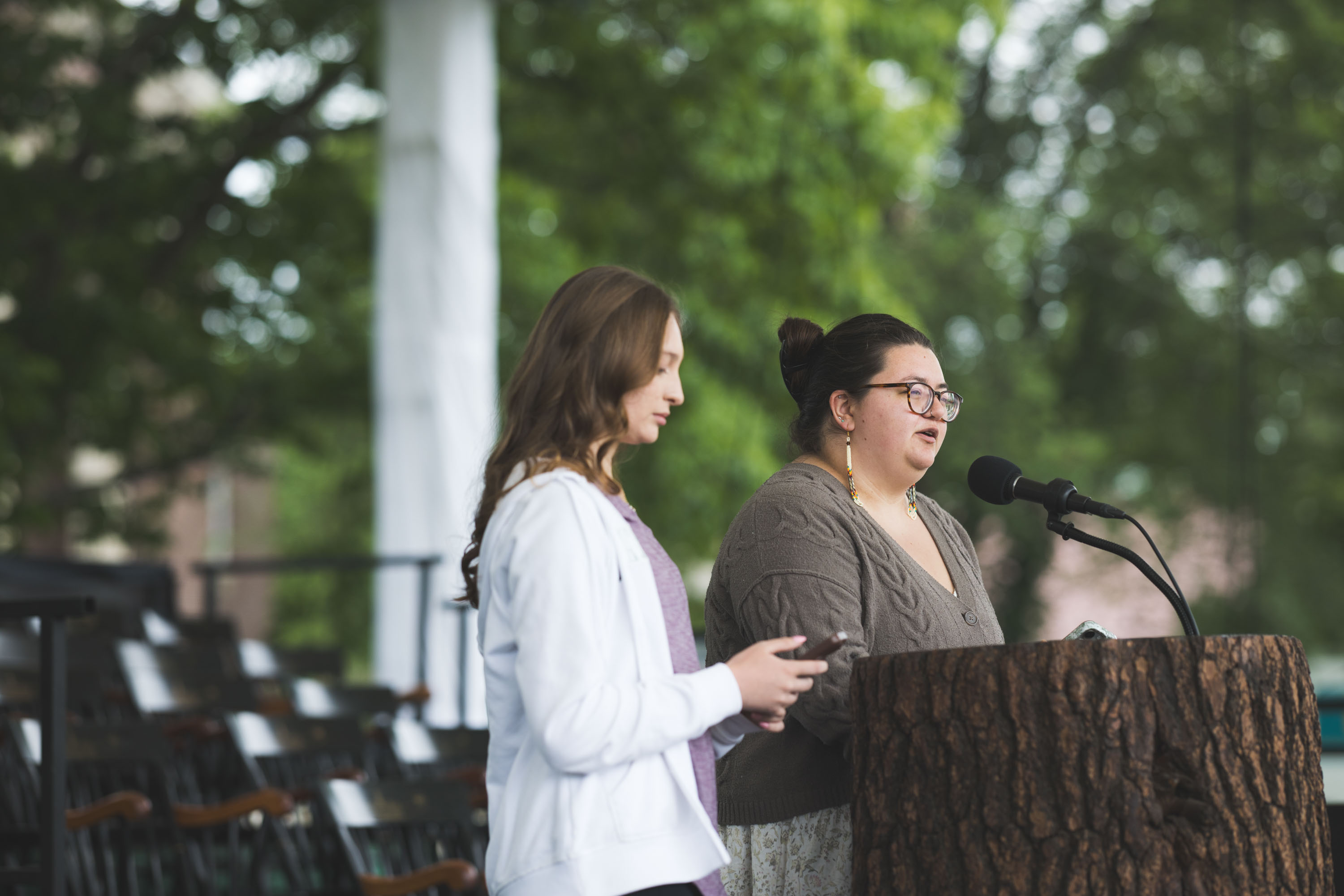 Sydney Hoose and Emma Tsosie at the mic and podium onstage