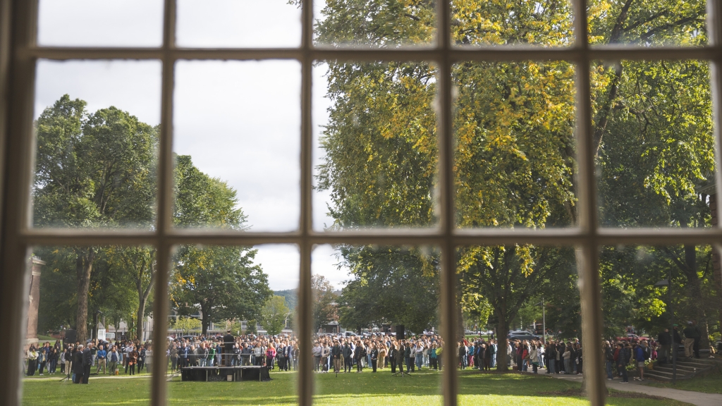 Looking out through a paned window onto a crowd gathered on Baker-Berry lawn