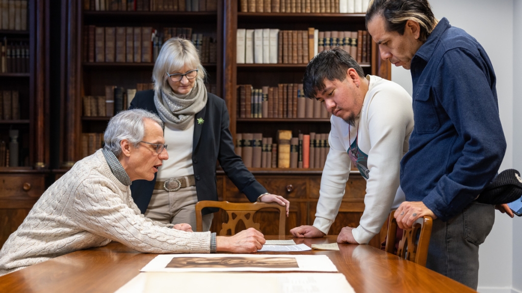 Osage visitors and library staff look at a letter and photograph in Rauner Special Collections Library.