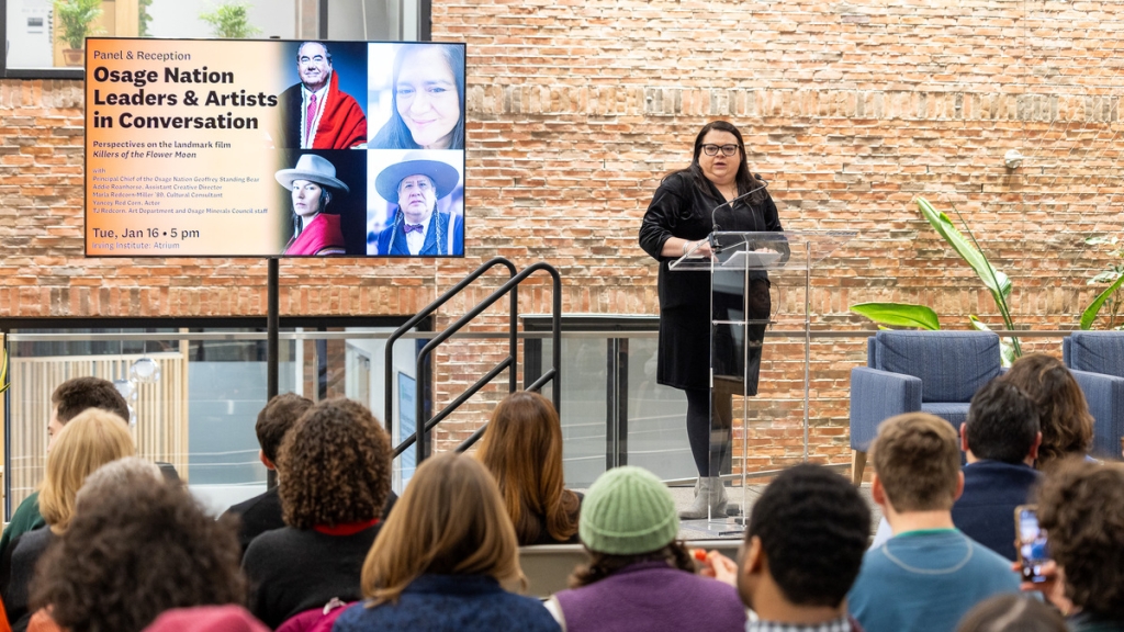 Jami Powell stands at a podium and gives the opening remarks for the panel.