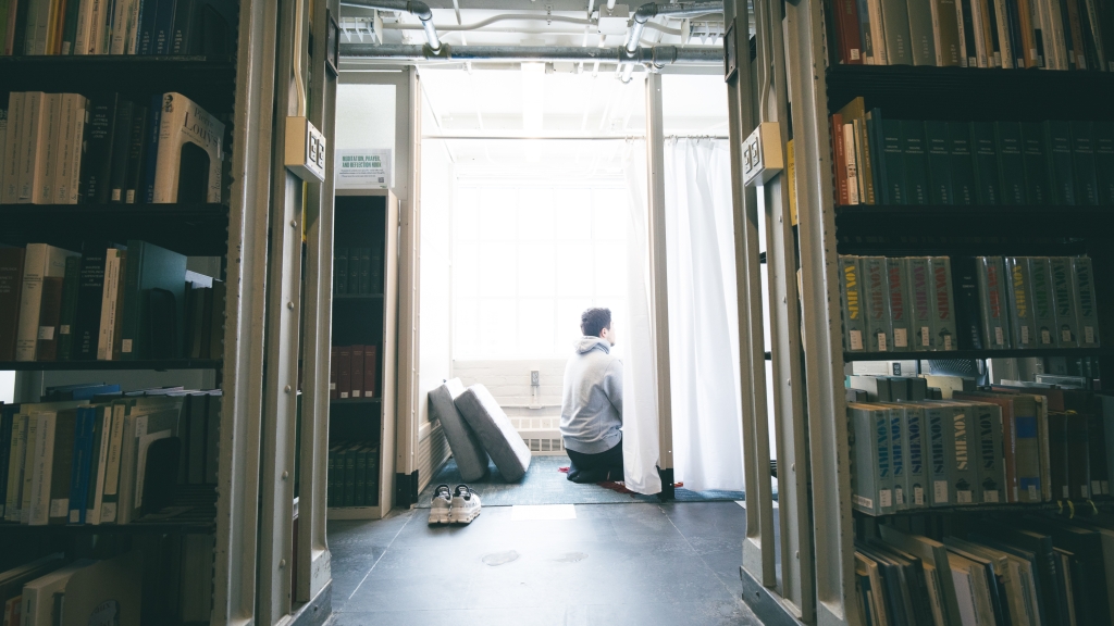 Amen Salha praying in the new nook in Baker-Berry Library